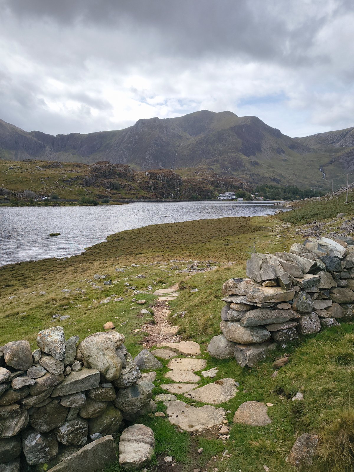 Stenen pad tussen twee droge stenen muurtjes dat als leidende lijn naar Llyn Ogwen en de bergen voert