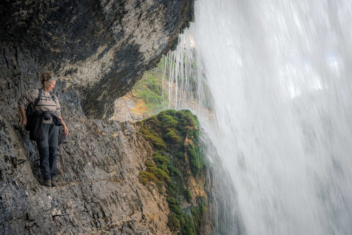 Uitzicht vanachter de waterval met water dat langs de rotsen naar beneden stroomt