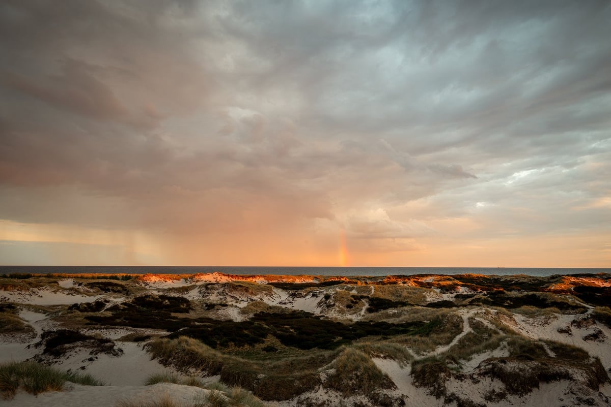Regenbui Dueodde strand zonsondergang
