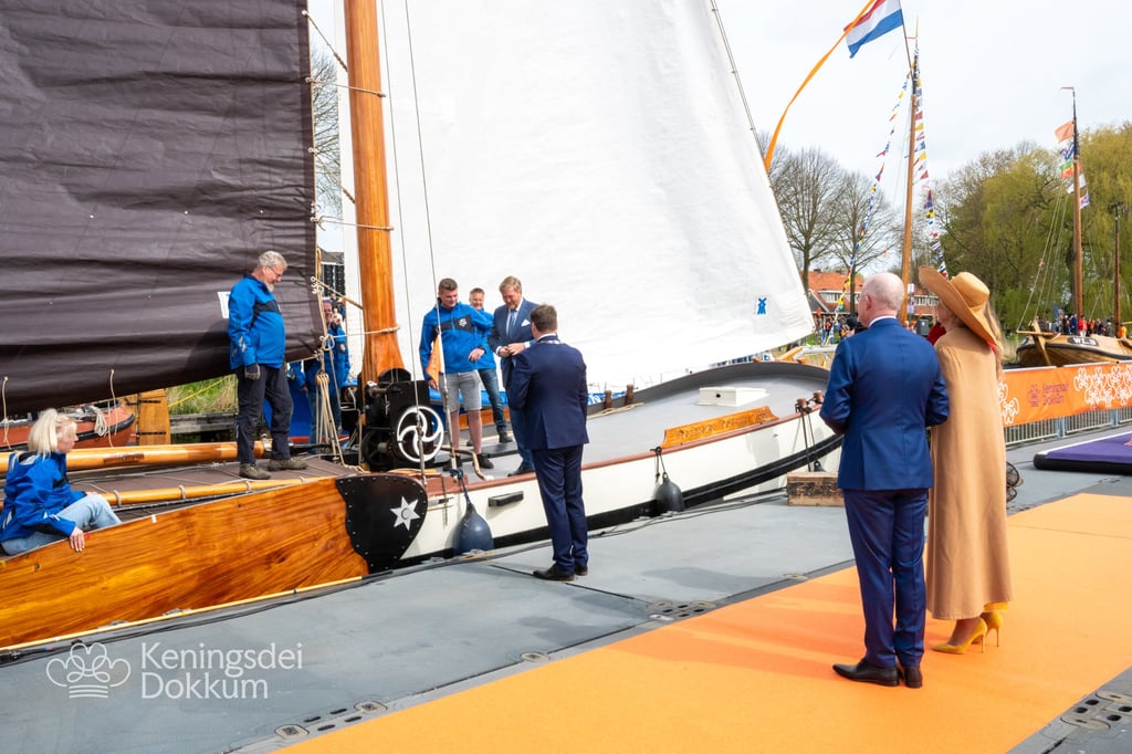 Dutch royals inspect traditional sailing vessel at Keningsdei Dokkum festival.